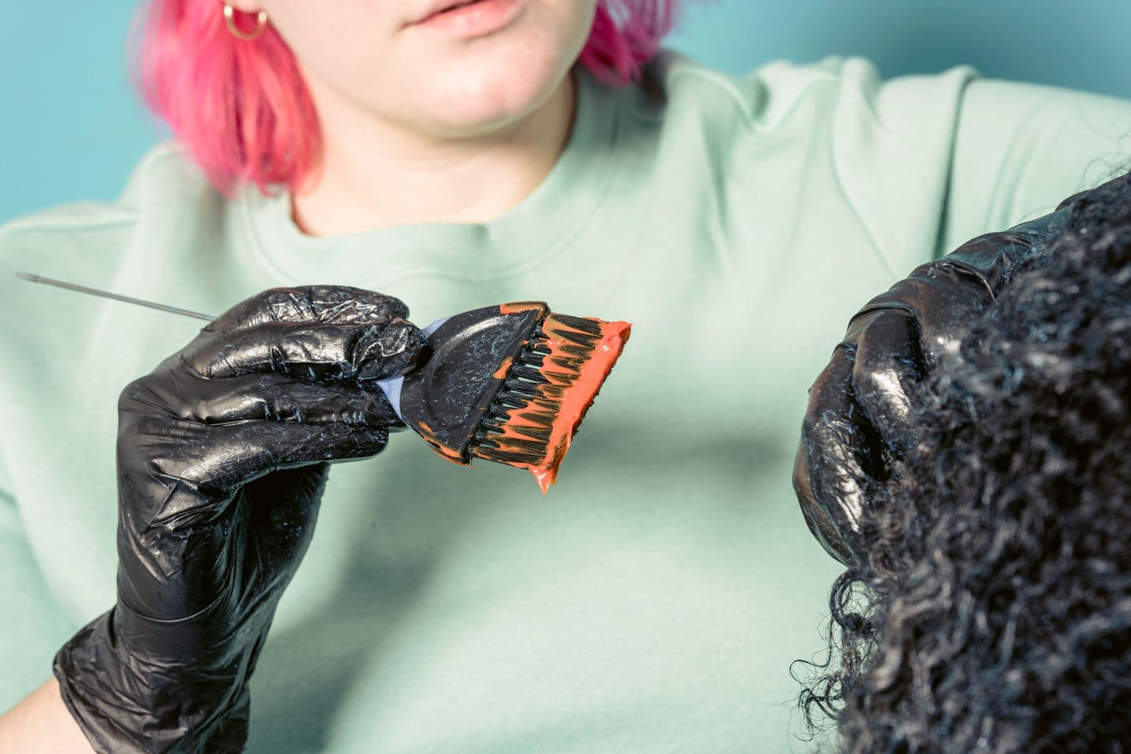 Colourist applying vivid colour to textured hair